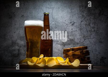 Lagerbier und Snacks auf Steintisch. Nachos, Chips Seitenansicht Stockfoto