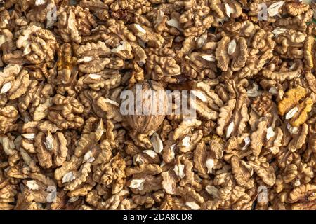 Nahaufnahme von großen geschälten Walnüssen Haufen. Walnusskerne und ganze Walnüsse Draufsicht. Frische rohe Walnüsse voller gesunder Fette, Ballaststoffe, Vitamine und Mineralstoffe Stockfoto