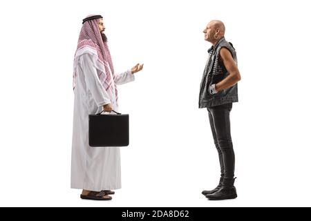 Ganzkörperaufnahme eines saudi-arabischen Mannes im Gespräch Zu einem kahlen Punk in Lederbekleidung isoliert auf Weiß Hintergrund Stockfoto