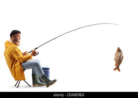 In voller Länge Profilaufnahme eines jungen Fischers, der darauf sitzt Ein Stuhl und fangen Fisch isoliert auf weißem Hintergrund Stockfoto