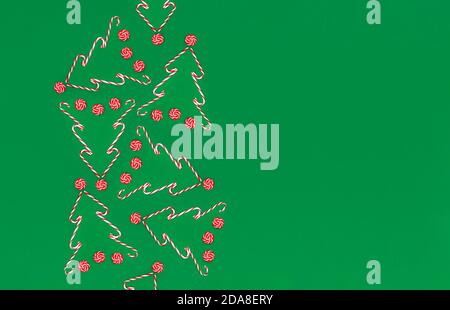 Bonbonkannen auf grünem Hintergrund mit Kopieplatz an der Seite. Weihnachten oder Neujahr flach lag. Stockfoto