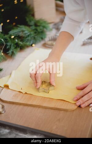 Weibliche Hände machen hausgemachte Weihnachtskekse aus nächster Nähe Stockfoto