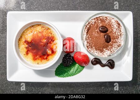 Draufsicht auf hausgemachtes Essen, Creme Brulee und Schockolat Sahne mit Erdbeere und Minze verlassen, Creme Brulee ist ein beliebtes Dessert, zeigt die Gerichte Stockfoto