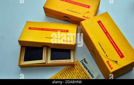 Eine Studioaufnahme von alten Kodak 4 x 4 cm Dias in einer offenen Kodak Farbtransparenzbox mit ähnlichen Boxen daneben. Stockfoto