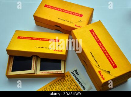 Eine Studioaufnahme von alten Kodak 4 x 4 cm Dias in einer offenen Kodak Farbtransparenzbox mit ähnlichen Boxen daneben. Stockfoto