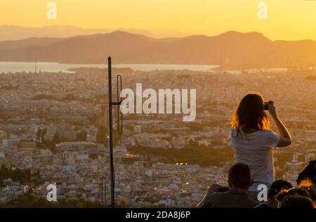 Touristen machen Schnappschüsse auf ihren Smartphones am Aussichtspunkt auf dem Lycabettus-Hügel im Zentrum Athens Griechenland - Foto: Geopix Stockfoto