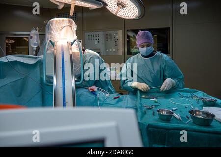 Ein Chirurg führt eine Defibrillatorimplantation in einem Krankenhaus durch Stockfoto
