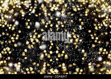 Schöner dunkler Hintergrund mit goldenen Lichtern und Schnee-Effekt Stockfoto