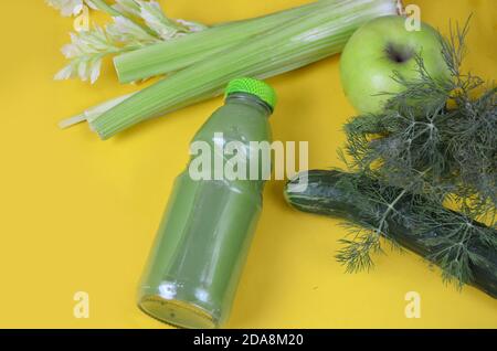 Frischer grüner Saft mit Apfel, Gurke, Sellerie auf gelbem Hintergrund Stockfoto