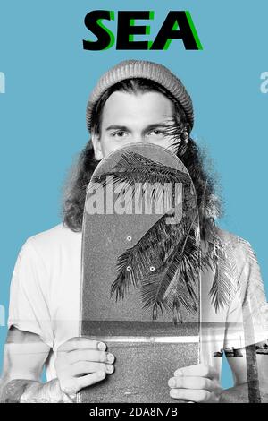 Junger Erwachsener Hipster Mann hält Skateboard in den Händen Stockfoto