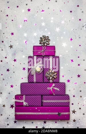 Weihnachtsbaum aus lila Geschenkschachteln, flache Lay-Komposition. Winterurlaub Konzept. Kreative Weihnachtskarte. Stockfoto