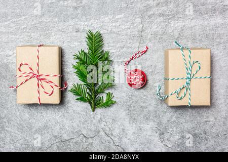 Weihnachtskomposition. Geschenke, immergrüner Baum und roter Weihnachtsschmuck auf grauem Steingrund. Weihnachten, Winter, Neujahr Konzept. Flach auflegen, Oberteil V Stockfoto