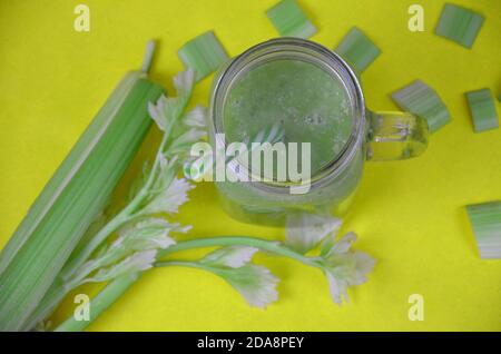 Grüner Smoothie im Glas-Einmachglas auf gelbem Hintergrund mit Kopierraum - Detox, vegan, vegetarisch gesundes Gemüsegetränk Stockfoto