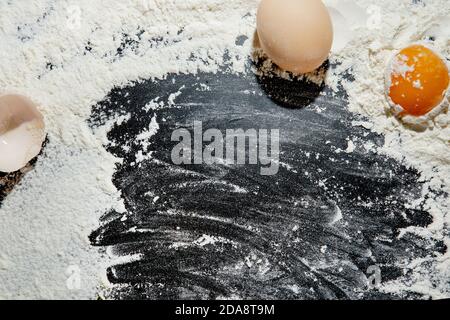 Frisch gekochte Pasta liegt auf einer dunklen, mit Mehl bestäubten Oberfläche. Italienische Pasta. Tagliatelle. Rohe Pasta. Italienische Pasta Rezept. Draufsicht, Kopierbereich Stockfoto