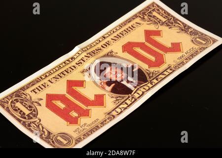 Gefälschte 1 US-Dollar-Banknote mit dem Gesicht der Angus Young AC/DC Rock Band Memorabilien von 1990 auf schwarzem Hintergrund Stockfoto