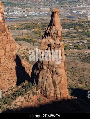 Ein Wingate Sandsteinturm, genannt Independence Monument im Monument Canyon. Colorado National Monument, Colorado, USA. Dahinter steht das küssende Coupl Stockfoto