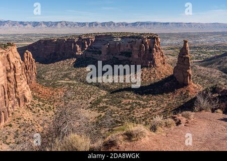 Ein Wingate Sandsteinturm, genannt Independence Monument im Monument Canyon. Colorado National Monument, Colorado, USA. Dahinter ist die Insel mit w Stockfoto