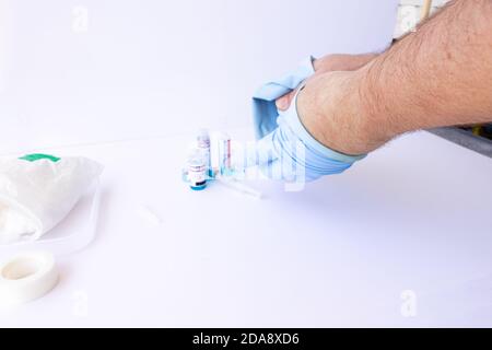 Arzt, Krankenschwester, Wissenschaftler, Forscher Hand in blauen Handschuhen hält Grippe, Masern, SARS, Coronavirus, covid-19-Impfstoff-Krankheit Vorbereitung für menschliche Klinika Stockfoto