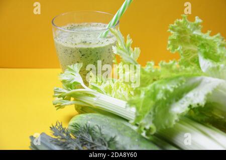 Gesunde grüne Smoothie und Zutaten auf gelb - Superfoods, Detox, Ernährung, Gesundheit, vegetarische Lebensmittel. Sellerie, Gurke, Petersilie, Dill. Eine Diät-Plan in einem Stockfoto