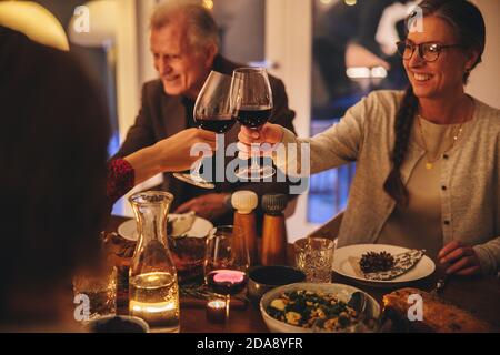 Mutter und Tochter toasting Wein am Weihnachtstisch. Familie genießen Weihnachtsessen zu Hause. Stockfoto