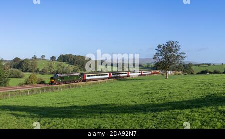 Der Touristenzug 'Staycation Express', der Coniston Cold, Yorkshire mit einer Lokomotive der Baureihe 37 passiert, Stockfoto