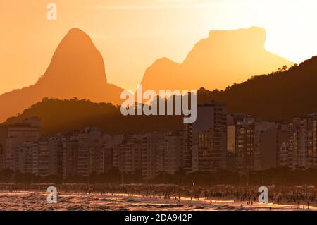 Landschaftlich schöner Blick auf den Sonnenuntergang am Copacabana Strand, Sonne geht hinter den Bergen, Rio de Janeiro, Brasilien Stockfoto