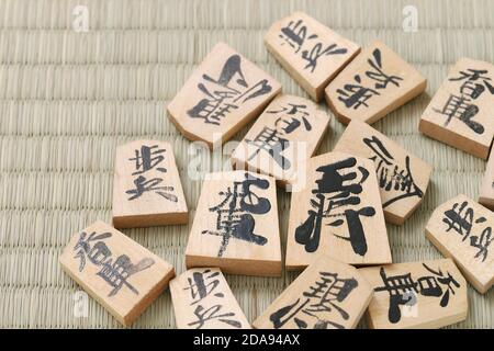 Japanische Shogi-Stücke auf Tatami-Hintergrund, Shogi ist japanisches Schach. Das Wort, das in dem Stück geschrieben ist, ist König. Stockfoto