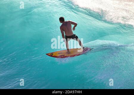 Atemberaubende Aufnahme eines silhouettierten Surfers mit einer klaren, sauberen Aquamarinwelle auf Maui. Stockfoto