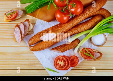 Tomaten, Brot und Kielbasa mit Schnittlauch auf Holzgrund. Nahaufnahme. Stockfoto