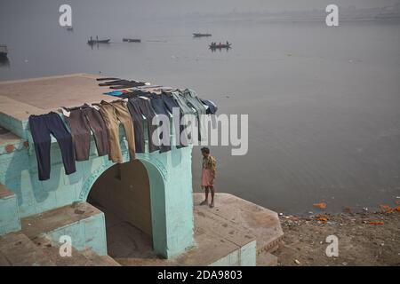 Varanasi, Indien, Januar 2008. Ein Mann wacht über Hosen, die in einem Ghat getrocknet werden. Stockfoto