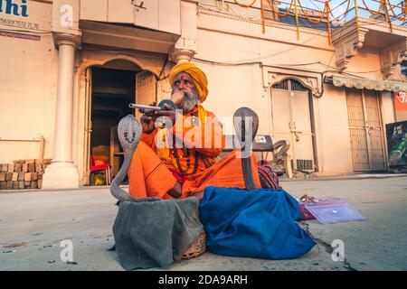 heilige baba Mönch heilige hypnotisieren eine Schlange Cobra Kundalini mit Flöte auf der Straße von varanasi, Indien. Stockfoto