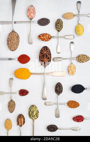 Aromatische Gewürze auf Löffeln auf weißem Hintergrund Stockfoto