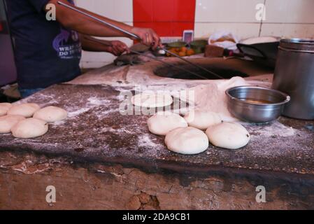 Mann, der Tandoori roti, indische Fladenbrot im Dorf in Jaipur Rajasthan Indien. Vollkorn roti in Tandoor Ofen gebacken. Ländliche Vintage Küche Stockfoto