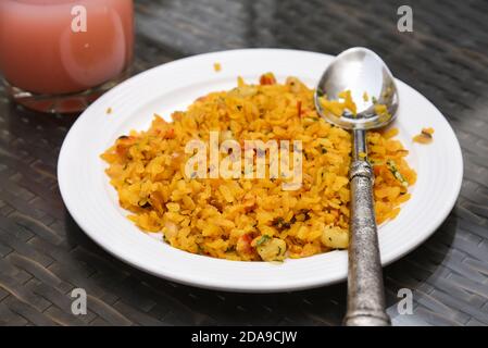 Poha oder Zwiebel Pohe mit Gurke würzig beliebt traditionelle indische Frühstück Lebensmittel, Snack in Jaipur, Rajasthan, Indien. Hergestellt mit Reisflocken geschlagen Reis. Stockfoto