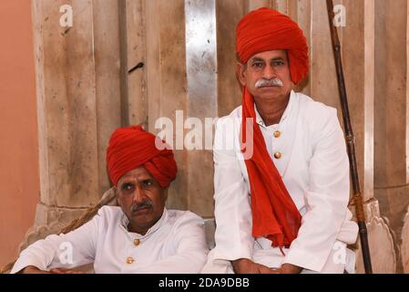 Indische Mann trägt traditionelle Kleidung roten Turban am Eingang des City Palace, Rajasthan, Nordindien. Stockfoto