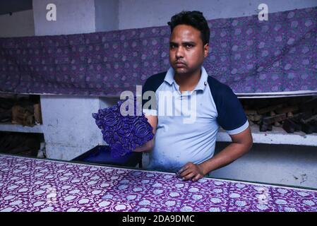 Indische Mann tun Holz Block Druck für Textil in Indien von Hand traditionelle Handarbeiten auf Leinen, Baumwolle Seide Textil, um ein Muster Rajasthan zu schaffen Stockfoto