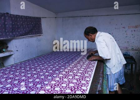 Indische Mann tun Holz Block Druck für Textil in Indien von Hand traditionelle Handarbeiten auf Leinen, Baumwolle Seide Textil, um ein Muster Rajasthan zu schaffen Stockfoto