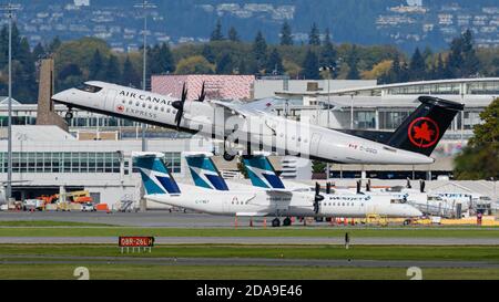 Richmond, British Columbia, Kanada. Oktober 2020. Air Canada Express und WestJet Encore DeHavilland Canada Dash 8-400 zweimotorige Turboprop-Regionalflugzeuge am Mittwoch, 14. Oktober 2020, Vancouver International Airport, Richmond, B.C. Quelle: Bayne Stanley/ZUMA Wire/Alamy Live News Stockfoto