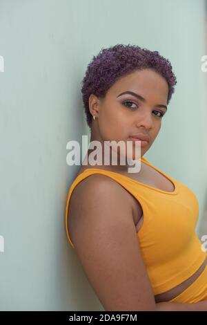 Schöne junge Frau lehnt an der Wand Stockfoto