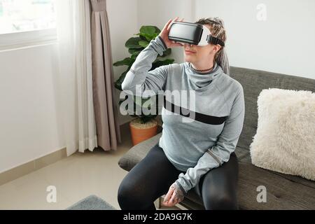 Lächelnde schwangere junge Frau trägt Virtual Reality-Headset und genießen Neues Spiel Stockfoto