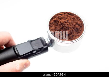 Barista Hand hält einen Metallhalter von der Kaffeemaschine Mit gemahlenem Kaffee im Inneren Stockfoto