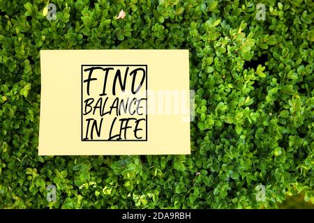 Motivierende Zitat finden Gleichgewicht im Leben auf Papier in einem Garten in der Natur geschrieben. Wohlfühlkonzept. Stockfoto