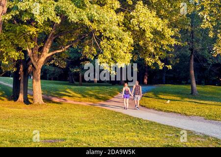 Montreal, Kanada - Juni, 2018: Das junge kanadische Paar geht Hand in Hand im Mount Royal Park in Montreal, Quebec, Kanada an einem sonnigen Sommernachmittag. Stockfoto