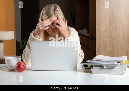 Unglücklich verärgert Frau mittleren Alters verwirrt depressiv mit finanziellen Problemen Oder Schulden online bezahlen Stockfoto