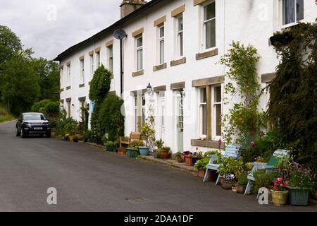 Reihe von traditionellen weiß getünchten Steinhütten in malerischen ländlichen Dorf, Land Rover Discovery Sport geparkt auf der Straße - Linton, North Yorkshire England Großbritannien. Stockfoto