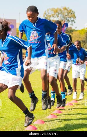 JOHANNESBURG, SÜDAFRIKA - 10. Nov 2020: Johannesburg, Südafrika - 29 2009. Juni: Diverse Kinder spielen Fußball in der Schule Stockfoto