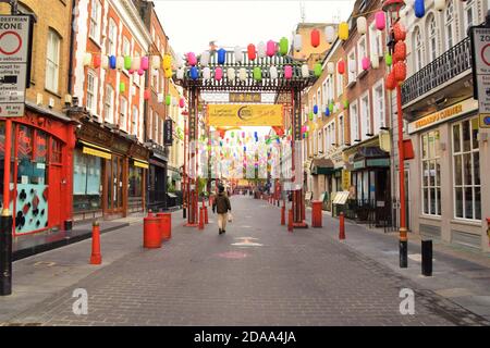 Ein Mann geht eine leere Gerrard Street in Chinatown, London, während der zweiten nationalen Sperre in England. Stockfoto