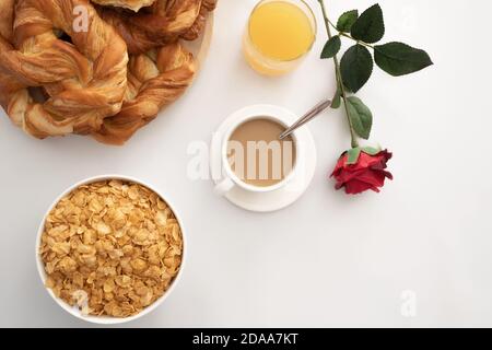 Frühstück mit Kaffee, Gebäck, Saft und Müsli Stockfoto