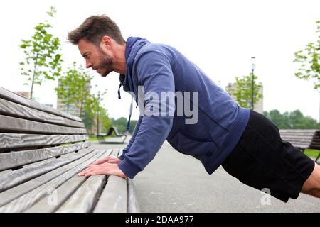 Seitenprofil Porträt von schönen Mann tun Push-up auf Bank Stockfoto