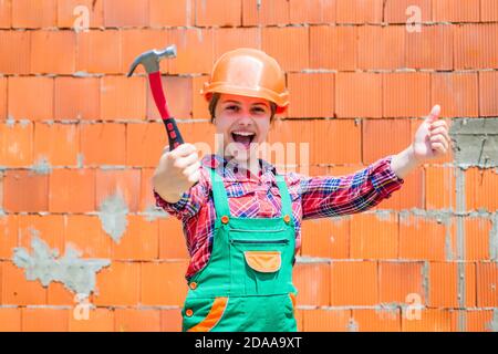 Fröhliche Kinderarbeiter mit Gebäude Uniform und Hammer-Werkzeug, Arbeiter. Stockfoto